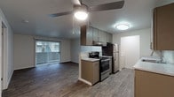 This single-floor unit offers a thoughtfully designed open layout that seamlessly connects the kitchen and living area. The kitchen is equipped with stainless steel appliances, including an electric range and refrigerator, complemented by contemporary taupe cabinetry, light stone-look countertops, and a tiled backsplash. A ceiling fan overhead provides both light and airflow, while wood-look flooring extends throughout the main living area, adding warmth and continuity to the space. A sliding glass door leads to an outdoor area, allowing natural light to flow into the living room.

The bedroom is generously sized, featuring soft carpeting and an impressive dual-closet configuration with mirrored sliding doors, offering abundant storage. A window in the bedroom provides views of the surrounding greenery and neighboring buildings, lending a pleasant outdoor connection. The bedroom also provides direct access to the full bathroom.

The bathroom is finished with a wood-toned vanity, a stone-look countertop, a large mirror with overhead lighting, and a full soaking tub with shower combination, all accented by brushed nickel hardware and wood-look tile flooring. An in-unit laundry area adds everyday convenience. The space combines functional design with modern finishes throughout, creating a comfortable and cohesive living environment.