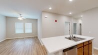 Located at 3825 Jonesboro Rd in South Fulton, Georgia, this single-story home offers four bedrooms and one bathroom within a efficiently arranged floor plan. The interior presents a clean, modern aesthetic characterized by neutral-toned walls, wood-look laminate flooring throughout the main living areas, and recessed lighting that brightens the space.

The open-concept kitchen and living room serve as the heart of the home. The kitchen is equipped with warm wood cabinetry, white countertops, and a full suite of stainless steel appliances including a range, microwave, and refrigerator. A peninsula with an integrated sink provides additional workspace and connects the kitchen visually to the living area, which features a ceiling fan and natural light from multiple windows.

The four bedrooms are practical in size, with the primary bedroom offering a dedicated closet with wire shelving. Bedrooms feature either carpet or wood-look flooring. The bathroom includes wood-look vinyl flooring, a vanity with wood cabinetry, and a shower-tub combination. A dedicated laundry room accommodates a full-size washer and dryer, adding everyday convenience to the layout.