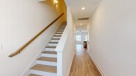 Located at 1801 Wilder Dr in Antioch, TN, this well-appointed two-story home offers three bedrooms and three full bathrooms across two thoughtfully designed floors. Light-toned hardwood-style flooring runs throughout, creating a cohesive and clean aesthetic from room to room.

The main floor opens into a bright living and dining area, where a stylish chandelier and a glass panel door invite natural light from the surrounding tree-lined views. The kitchen is a functional centerpiece, featuring gray shaker-style cabinetry, white quartz countertops, a kitchen island with an undermount sink, stainless steel appliances, and pendant lighting — a modern and practical space for daily living.

A staircase with warm wood treads and a classic white riser design connects the floors, framed by a clean hallway leading toward the main living areas. Upstairs, the generously sized primary bedroom includes vaulted ceilings, a ceiling fan, and a private en-suite bathroom. The additional bedrooms are well-proportioned, each featuring ceiling fans and windows with outdoor views. The bathrooms are finished with white vanities, quartz countertops, and clean chrome and matte black fixtures. Two closets provide ample storage across the home, rounding out a practical and polished layout.