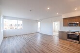 Located at 3222 Mission Village Dr in San Diego, CA, this modern 2-bedroom, 2-bathroom residence offers a thoughtfully designed single-floor layout with clean, contemporary finishes throughout. The open-concept living, dining, and kitchen area is anchored by light wood-tone luxury vinyl plank flooring and crisp white walls, creating a bright and airy atmosphere. Large windows flood the space with natural light and frame views of the surrounding neighborhood. A glass-panel door leads directly to a private balcony, seamlessly extending the living area outdoors. The kitchen is well-appointed with warm wood-grain cabinetry, white countertops, a full suite of stainless steel appliances including a refrigerator, range, microwave, and dishwasher, and recessed lighting overhead. Both bedrooms feature plush carpet flooring and generous windows that bring in abundant daylight. The primary bedroom is a comfortable retreat with its own closet. The bathrooms are finished with modern wood-tone vanities, white countertops, large mirrors, and wood-look flooring, maintaining a cohesive aesthetic throughout. Additional conveniences include dedicated closets, a utility room, and in-unit laundry, rounding out this well-equipped and stylish San Diego residence.