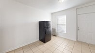 This 520 square foot apartment in Chicago offers a practical living space with two bedrooms and one bathroom. The primary bedroom is particularly spacious at 190 square feet, providing ample room for a comfortable retreat. The kitchen, while compact, is equipped with essential appliances including a gas range and refrigerator. Dark wood cabinetry and a modest countertop area offer storage and preparation space.

The bathroom has been updated with modern fixtures, featuring a combined tub and shower with neutral tiled walls. A single vanity provides storage beneath a clean, white countertop. Throughout the apartment, the flooring alternates between carpeting in the bedrooms and living areas, and tile in the kitchen and bathroom, creating distinct spaces within the open floor plan.

Natural light filters through windows in each room, complementing the bright white walls that contribute to an airy feel despite the compact square footage. A radiator in one of the bedrooms suggests the building may be older, adding a touch of vintage charm to the otherwise contemporary space. The overall layout maximizes the available area, making efficient use of the 520 square feet to provide a comfortable living environment in an urban setting.