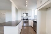 Located at Kingsbridge Court in North York, Toronto, this 2-bedroom, 1-bathroom unit offers a clean, modern aesthetic throughout its well-planned single-floor layout. Light wood laminate flooring runs throughout the living spaces, complementing crisp white walls and abundant natural light.

The spacious living room provides a generous open area with a large window framing views of the surrounding neighbourhood and mature trees. Adjacent to the living space, the dining area flows naturally into a well-appointed kitchen featuring white shaker-style cabinetry, dark countertops, a white subway tile backsplash, and a full suite of stainless steel appliances including a range, over-the-range microwave, and dishwasher. A window above the sink further brightens the kitchen.

Both bedrooms are comfortably sized, each featuring large windows with baseboard heating beneath, light flooring, and clean white walls. The primary bedroom offers a generous footprint with ample natural light and neighbourhood views.

The bathroom is finished with floor-to-ceiling white subway tile surrounding a soaker tub and shower combination, paired with chrome fixtures for a polished look. A dedicated closet and hallway provide practical storage. The overall ambiance of the unit is bright, clean, and move-in ready.