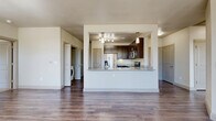 Located at 200 Philomena Dr in Kyle, TX, this single-story, 3-bedroom, 2-bathroom home offers a well-designed layout with a comfortable and functional feel throughout. The open-concept living and kitchen area serves as the heart of the home, featuring rich wood-style flooring, neutral walls, and large windows that invite generous natural light and views of the surrounding greenery. A ceiling fan adds to the comfort of the bright, airy living space.

The kitchen is a standout feature, showcasing a broad granite-topped peninsula with an undermount sink, dark espresso cabinetry, stainless steel appliances including a French door refrigerator, a smooth-top range, and overhead track lighting with pendant accents. A pantry and an in-unit utility room with washer connections are conveniently accessible from the kitchen area.

The primary bedroom is spaciously proportioned and includes a large walk-in closet with extensive wire shelving. The secondary bedrooms are carpeted and well-lit with windows, each serviced by ample closet space. The bathrooms feature dark cabinetry, granite vanities, wood-style flooring, and a tiled tub-shower combination. A balcony provides additional outdoor access, completing this thoughtfully appointed home.