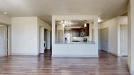 Located at 200 Philomena Dr in Kyle, TX, this single-story, 3-bedroom, 2-bathroom home offers a well-designed layout with a comfortable and functional feel throughout. The open-concept living and kitchen area serves as the heart of the home, featuring rich wood-style flooring, neutral walls, and large windows that invite generous natural light and views of the surrounding greenery. A ceiling fan adds to the comfort of the bright, airy living space.

The kitchen is a standout feature, showcasing a broad granite-topped peninsula with an undermount sink, dark espresso cabinetry, stainless steel appliances including a French door refrigerator, a smooth-top range, and overhead track lighting with pendant accents. A pantry and an in-unit utility room with washer connections are conveniently accessible from the kitchen area.

The primary bedroom is spaciously proportioned and includes a large walk-in closet with extensive wire shelving. The secondary bedrooms are carpeted and well-lit with windows, each serviced by ample closet space. The bathrooms feature dark cabinetry, granite vanities, wood-style flooring, and a tiled tub-shower combination. A balcony provides additional outdoor access, completing this thoughtfully appointed home.