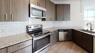Located at 20 Romney St in the heart of Charleston, SC, this single-floor unit offers a thoughtfully designed layout with modern finishes throughout. The kitchen is a standout feature, showcasing rich dark wood cabinetry, granite countertops, a classic white subway tile backsplash, and a full suite of stainless steel appliances including a range, microwave, and dishwasher — ideal for both everyday cooking and entertaining. The open living area is bathed in natural light streaming through large windows with blinds, and features warm wood-look luxury vinyl flooring that adds a clean, contemporary feel. The carpeted bedrooms provide a comfortable retreat, each benefiting from natural light and generous wall space. Two bathrooms continue the refined aesthetic with granite-topped dark wood vanities, wood-look flooring, and a tiled shower-tub combination. Clean white walls and neutral tones throughout create a bright, airy ambiance. The floorplan model reveals a well-organized layout that maximizes the use of space, offering a functional flow between living, dining, kitchen, and private sleeping areas — all within one of Charleston's vibrant neighborhoods.