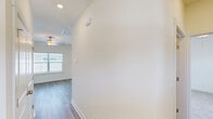 Located on Mulberry Blvd in Port Wentworth, Georgia, this single-story, one-bedroom, one-bathroom home offers a well-designed layout with modern finishes throughout. The open-concept living and kitchen area serves as the heart of the home, featuring light wood-look flooring, a ceiling fan, and a sliding glass door that invites natural light and outdoor access. The kitchen is a standout, equipped with white shaker cabinetry, a gray subway tile backsplash, granite countertops, stainless steel appliances including a refrigerator, microwave, and range, and a central island with a stainless undermount sink illuminated by pendant lighting above. A dedicated pantry provides additional storage. The bedroom is carpeted for comfort, features a ceiling fan, a window with natural light, and includes access to a walk-in closet with built-in shelving. The full bathroom is finished with wood-look tile flooring, a white vanity with granite countertops, and a tub-shower combination enclosed by a sliding glass door. A hallway connects the rooms efficiently, and recessed lighting and neutral wall tones throughout lend a clean, cohesive aesthetic to the entire space.