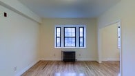 Located at 58 N Lansdowne Avenue in Lansdowne, Pennsylvania, this single-floor space combines classic architectural character with a clean, updated aesthetic. The interior showcases gleaming hardwood floors that run throughout, reflecting natural light and adding warmth to the overall ambiance. Crisp white trim and soft, neutral-toned walls create a bright and inviting atmosphere. A standout feature of the main living area is the large multi-pane window set with bold black frames, allowing ample natural light to flood the room while offering pleasant views of the surrounding neighborhood. Beneath the window, a traditional cast-iron radiator serves as both a functional heating element and a charming nod to the building's historic character. The high placement of the ceiling contributes to a sense of openness and spaciousness throughout the room. A wide doorway connects the living space to an adjacent room, suggesting a practical and flowing floor plan. The overall design balances vintage details — such as the radiator and classic window styling — with fresh, well-maintained finishes, making this a space that feels both timeless and move-in ready. Situated in the borough of Lansdowne, the property offers convenient access to the surrounding Delaware County community.