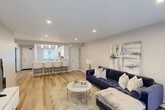 Located at 200 La Bonne Vie Dr in East Patchogue, NY, this single-floor, 2-bedroom, 1-bathroom residence offers a thoughtfully designed open-concept layout. The combined kitchen and living area serves as the heart of the home, where crisp white shaker cabinets, marble-look stone countertops, and a peninsula with seating for three are illuminated by elegant pendant lights. Stainless steel appliances and recessed lighting complete the kitchen's modern aesthetic. The living room flows seamlessly from the kitchen, featuring light hardwood flooring, recessed lighting, and a sliding glass door that invites abundant natural light and outdoor access. The primary bedroom is generously proportioned, featuring a large double closet with paneled sliding doors and hardwood flooring. The second bedroom offers plush carpeting, a ceiling fan, a natural light-filled window, and views of the surrounding greenery. The full bathroom is finished with large-format neutral tile surrounding the tub-shower combination and a marble-top vanity. With four closets throughout the residence providing ample storage, and a neutral, light-filled color palette carried throughout, this space offers a clean, contemporary atmosphere well-suited for comfortable everyday living.
