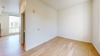 Located at 22 Etruria St in Seattle's Lower Queen Anne neighborhood, this 2-bedroom unit offers a thoughtfully designed single-floor layout that maximizes every square foot. Light wood-tone flooring runs throughout, complementing the clean white walls and creating a bright, cohesive feel across all rooms.

The combined kitchen and living area serves as the heart of the unit. The kitchen is outfitted with dark lower cabinetry, white upper cabinets, white quartz countertops, a classic subway tile backsplash, stainless steel appliances including a range and dishwasher, and a built-in microwave — delivering a polished, modern aesthetic.

A long hallway connects the living space to the two bedrooms, providing clear separation between the living and sleeping areas. The primary bedroom is a comfortable size, featuring a large window that allows natural light to fill the space. The second bedroom is similarly bright and clean, with the same warm wood flooring. Both rooms include baseboard heating for year-round comfort. A dedicated closet offers valuable storage, while in-unit laundry adds everyday convenience. The overall ambiance is clean, modern, and move-in ready.