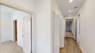 Located at 10030 Garland Rd in Dallas, TX, this two-story home offers a thoughtfully designed layout spread across two levels. The ground floor houses a spacious attached garage with an automatic opener and bright overhead lighting, along with a convenient laundry area and hallway. A staircase leads to the main living level above, where an open-concept kitchen and living room create a bright, airy atmosphere. The kitchen is outfitted with contemporary flat-panel cabinetry in a warm wood tone, white quartz countertops, a subway tile backsplash, stainless steel appliances, and a central island. The living area features light hardwood-style flooring and large windows that fill the space with natural light. Both bedrooms offer plush carpeting and soaring vaulted ceilings that amplify the sense of space, with ample natural light streaming through oversized windows. The generously sized primary bedroom includes an en-suite bathroom and walk-in closet. Both bathrooms are finished with marble-look tile flooring, soaker tubs with marble-tiled surrounds, wood-tone vanities, and clean white countertops. Each bedroom is served by a dedicated closet, completing this well-appointed home.