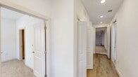 Located at 10030 Garland Rd in Dallas, TX, this two-story home offers a thoughtfully designed layout spread across two levels. The ground floor houses a spacious attached garage with an automatic opener and bright overhead lighting, along with a convenient laundry area and hallway. A staircase leads to the main living level above, where an open-concept kitchen and living room create a bright, airy atmosphere. The kitchen is outfitted with contemporary flat-panel cabinetry in a warm wood tone, white quartz countertops, a subway tile backsplash, stainless steel appliances, and a central island. The living area features light hardwood-style flooring and large windows that fill the space with natural light. Both bedrooms offer plush carpeting and soaring vaulted ceilings that amplify the sense of space, with ample natural light streaming through oversized windows. The generously sized primary bedroom includes an en-suite bathroom and walk-in closet. Both bathrooms are finished with marble-look tile flooring, soaker tubs with marble-tiled surrounds, wood-tone vanities, and clean white countertops. Each bedroom is served by a dedicated closet, completing this well-appointed home.