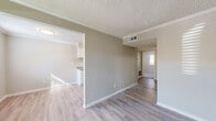 Located at 9801 Meadowglen Ln in Houston, TX, this single-story 2-bedroom, 2-bathroom home offers a clean, functional layout with updated finishes throughout. The living area features light wood-look flooring, neutral warm-gray walls, crown molding, and a textured ceiling, with natural light streaming in through sliding glass doors that open to an outdoor area. The kitchen is designed as a galley-style space with white cabinetry, granite-look countertops, and black stainless appliances including a refrigerator, range, and dishwasher — all set on the same light wood-look flooring. Both bedrooms are carpeted and offer a calm, neutral palette with textured ceilings and natural window light. The primary bedroom provides a comfortable, spacious retreat. Closets include built-in shelving for organized storage. The two bathrooms differ in configuration — one features a full soaking tub with shower combination and granite-look vanity, while the second offers a stand-up shower with wood-look tile flooring. Hallways connect the rooms with ease, and the entrance welcomes residents into a well-organized floor plan. This home balances practicality and comfort in a straightforward, move-in-ready package.