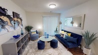This 2-bedroom, 2-bathroom unit is thoughtfully designed to maximize comfort and functionality across a single floor. The open-concept living area features warm wood-look flooring throughout and connects seamlessly to the dining space and kitchen. The living room is bright and welcoming, with a sliding glass door fitted with vertical blinds that allows natural light to filter in. A pass-through window connects the living area to the kitchen, enhancing the open feel of the shared spaces. The kitchen is well-equipped with rich dark wood cabinetry, granite-style countertops, and stainless steel appliances, including a range, microwave, and refrigerator, along with a dishwasher. The dedicated dining area accommodates a round glass table and provides a defined space for meals. Both bedrooms are carpeted and generously sized, each offering ample room for full bedroom furniture sets and featuring windows for natural light. The two bathrooms are clean and functional, each including a full tub-shower combination and wood-look flooring. Storage is addressed throughout with closet space visible in multiple areas of the unit, making this a practical and comfortable home.