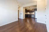 This single-story residence offers a thoughtfully designed layout with a consistent blend of warm finishes and practical features throughout. The kitchen serves as a standout element, showcasing rich dark espresso cabinetry extending to the ceiling, granite countertops, a tile backsplash, and a full suite of stainless steel appliances including a gas range, microwave, dishwasher, and refrigerator. Under-cabinet lighting and a pendant track fixture overhead enhance functionality and ambiance. An adjacent walk-in pantry provides generous storage. Warm hardwood flooring flows through the kitchen, entry, and main living areas, complementing the neutral wall tones.

The living spaces benefit from vaulted ceilings that lend an airy, open feel, while a French door opens to an outdoor area, inviting natural light and exterior views. Multiple windows fitted with blinds further brighten the carpeted bedroom areas, which feature vaulted ceilings and access to walk-in closets with built-in shelving. The bathroom is finished with granite countertops, dark cabinetry, oil-rubbed bronze fixtures, a large framed mirror, and a tiled tub-shower combination. Tile flooring completes the bathroom, tying together a cohesive, well-detailed interior.