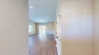 Located at 5541 Foothills Dr in Williamsburg, Michigan, this single-story, 2-bedroom, 2-bathroom home offers a clean, modern design with thoughtful finishes throughout. The open living area welcomes you with warm wood-look luxury vinyl plank flooring, recessed lighting, and abundant natural light streaming in through large windows and sliding glass doors. A stylish barn-style door with matte black hardware adds a contemporary farmhouse touch near the entrance.

The kitchen is well-equipped with crisp white shaker cabinets, granite countertops, a stainless steel sink and dishwasher, and wood-look flooring — all accented by matte black hardware for a cohesive modern aesthetic. A window above the sink brings in natural light.

The spacious primary bedroom features plush carpeting, a ceiling fan with a sleek black finish, and a walk-in closet outfitted with multi-tier wire shelving for ample storage. The second bedroom is equally comfortable with soft carpet and neutral wall tones. Both bathrooms are finished with granite vanity tops, white shaker cabinetry, and wood-look tile flooring.

A dedicated laundry room houses side-by-side Whirlpool washer and dryer units beneath overhead white cabinetry. Hallways connect the rooms seamlessly, completing this efficient and well-designed single-floor layout.