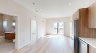 Located at 130 W Girard Ave in Philadelphia's vibrant Fishtown/Northern Liberties neighborhood, this 2-bedroom, 2-bathroom unit offers a thoughtfully designed, modern interior with a clean, contemporary aesthetic throughout. Light-toned hardwood flooring flows seamlessly across the entire unit, complementing the crisp white walls and recessed lighting overhead.

The open-concept kitchen and living area serves as the heart of the home. The kitchen features warm wood cabinetry extending to the ceiling, white quartz countertops, a white tile backsplash, and a full suite of stainless steel appliances including a French-door refrigerator, dishwasher, gas range, and built-in microwave. The living area is bright and airy, benefiting from a large sliding glass door that floods the space with natural light and provides views of the Philadelphia cityscape.

Both bedrooms are well-proportioned, featuring large windows with neighborhood views and continued hardwood flooring. The primary bedroom includes a double-door closet for ample storage, while a total of three closets are distributed throughout the unit. The two bathrooms are finished in a modern style with floating wood vanities, white countertops, large-format tile flooring, and a tub-shower combination in one. An in-unit laundry area adds everyday convenience to this polished urban residence.