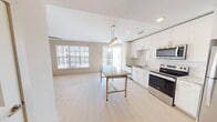This 830 square foot apartment offers a thoughtfully designed living space with two bedrooms and two full bathrooms. The heart of the home is the open-concept kitchen, featuring sleek white cabinetry, stainless steel appliances, and a stylish pendant light fixture over a granite-topped island. The kitchen's subway tile backsplash and light wood flooring add to its contemporary appeal.

Both bedrooms are generously sized, with the primary bedroom measuring 130 square feet. They feature plush carpeting, ceiling fans, and large windows that flood the rooms with natural light. The bathrooms are modern and well-appointed, with one offering a shower/tub combination and the other a spacious walk-in shower. Both have granite countertops and ample storage.

The apartment boasts city views from its windows and balcony, providing a connection to the urban surroundings. Closet space is abundant, with wire shelving systems for optimal organization. The unit is part of a multi-story complex with elevator access and shared amenities.

Overall, this apartment combines functionality with contemporary style, offering a comfortable living space in an urban setting.