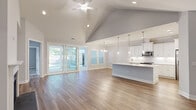 Located at 115 Beaumont Oaks Dr in Wilmington, NC, this well-appointed single-story home offers three bedrooms and four bathrooms across a thoughtfully designed floor plan. The open-concept living, dining, and kitchen area serves as the heart of the home, featuring warm hardwood-style flooring, crown molding, and large sliding glass doors that flood the space with natural light and provide direct access to the patio. The dining area is accented by an elegant chandelier and generous windows with plantation shutters.

The kitchen is outfitted with crisp white shaker cabinetry, light quartz countertops, a classic subway tile backsplash, and stainless steel appliances, creating a clean and functional workspace. The spacious primary bedroom includes a well-sized walk-in closet with wire shelving, while the en-suite bathroom features a glass-enclosed shower, white vanity with ample drawer storage, and tile flooring. Secondary bedrooms offer plush carpeting and closet access. A dedicated laundry room houses a full-size washer and dryer. The home also includes an attached garage, an outdoor patio with a fenced backyard, and additional exterior storage, rounding out this move-in-ready property.
