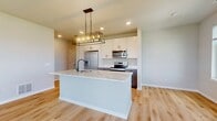 This contemporary townhouse in Elgin, Illinois, offers a thoughtful layout across 1,140 square feet. The two-story residence features two bedrooms and three bathrooms, providing ample space for comfortable living. The primary bedroom is particularly generous at 200 square feet, ensuring a luxurious retreat.

The interior is characterized by a bright, airy ambiance, thanks to large windows that flood the rooms with natural light and offer views of the surrounding neighborhood. The design emphasizes clean lines and a neutral color palette, creating a modern and versatile living space.

Flooring varies throughout the home, with plush carpeting in the bedrooms and sleek hardwood in the main living areas and bathrooms. The bathrooms are well-appointed, featuring contemporary fixtures and finishes. One bathroom showcases a stylish vanity with ample storage and a glass-enclosed shower.

The kitchen, while not fully visible in the provided images, appears to have modern cabinetry and counter space. Additional amenities include a utility room and a walk-in closet, enhancing the home's functionality and storage options.

The property's layout is efficiently designed, with a staircase connecting the two floors. The ground floor covers 60 square feet, while the main living area on the first floor spans 1,070 square feet. This townhouse offers a harmonious blend of style and practicality in a desirable Elgin location.