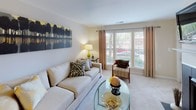 Located at 9333 Clocktower Place in Fairfax, Virginia, this well-designed single-floor residence offers a thoughtfully laid-out floor plan with multiple bedrooms, a welcoming living area, a fully equipped kitchen, and updated bathrooms. The living room serves as the heart of the home, featuring plush carpeting, large windows dressed with elegant curtains that invite abundant natural light, and an open sightline into the dining area accented by warm yellow tones. A fireplace adds a cozy focal point to the space. The kitchen is outfitted with rich dark cabinetry, granite countertops, stainless steel appliances including a gas range, built-in microwave, dishwasher, and refrigerator, all complemented by durable hardwood-style flooring. The primary bedroom is a serene retreat, offering generous proportions, soft carpeting, and large windows with outdoor views. Additional bedrooms are equally well-appointed, each with plush carpet, natural light, and versatile layouts suitable for sleeping or work-from-home arrangements. The bathroom features a granite-topped vanity with dark wood cabinetry and a large mirror. Throughout, the unit presents a cohesive, neutral palette with warm accent tones, creating an inviting and functional living environment.