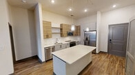This contemporary apartment in Herndon, VA, offers 960 square feet of efficiently designed living space. The unit boasts two bedrooms, including a primary bedroom of 140 square feet, and three full bathrooms. The single-floor layout maximizes functionality and flow.

The kitchen is a highlight, featuring modern appliances including a stainless steel refrigerator and built-in microwave. White subway tile backsplash complements the two-tone cabinetry, creating a clean and stylish aesthetic. The open concept allows for easy interaction between the kitchen and living areas.

Bathrooms are tastefully appointed with large vanities, undermount sinks, and spacious showers. One bathroom includes a combination shower/tub with white tile surround. The bedrooms are generously sized, with large windows providing natural light and views of the surrounding area.

Throughout the apartment, warm wood-look flooring adds a touch of elegance and continuity. Ample closet space, including walk-in closets with custom organizers, offers abundant storage options. The neutral color palette and modern fixtures create a fresh, inviting ambiance suitable for various decorating styles.

Located at 13280 Woodland Park Rd in Herndon, this apartment combines contemporary design with practical living, ideal for those seeking a modern, low-maintenance lifestyle in a convenient location.