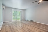Located at 1624 Fordem Ave in Madison, Wisconsin, this 2-bedroom, 2-bathroom single-floor residence offers a well-organized layout designed for comfortable everyday living. The open-concept living and dining area is bright and welcoming, featuring light hardwood-style flooring, a ceiling fan with light fixture, baseboard heating, and a sliding glass door that leads to a private patio with views of the surrounding greenery. A wall-mounted mini-split unit provides additional climate control in the living space. The kitchen is equipped with rich warm-toned cabinetry, granite-style countertops, stainless steel appliances including a refrigerator, range, and microwave, and a peninsula that opens to the living and dining areas — ideal for casual entertaining. Both bedrooms are carpeted and include ceiling fans, natural light from windows, and access to ample closet space, with four closets distributed throughout the unit. The primary bedroom is generously sized and connects to a full bathroom featuring a wide vanity with warm wood cabinetry, a large mirror, and a tiled shower-tub combination. A second full bathroom with a tiled tub-shower is also available. A dedicated entrance and hallway provide a smooth transition into the main living areas of the home.