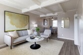 Located at 604 Leslie Dr in Salinas, CA, this two-story, 2-bedroom, 2-bathroom home offers a well-designed layout spread across two floors. The main level features a bright, open living room with distinctive exposed beam ceilings, light hardwood flooring, and large windows that invite an abundance of natural light. The living area flows seamlessly into the dining room, which is accented by a ceiling fan and connects to the kitchen. The kitchen is outfitted with white shaker cabinetry, light stone countertops, a classic subway tile backsplash, and stainless steel appliances including a gas range and dishwasher. A half bathroom on this level features a pedestal sink with brushed nickel fixtures and warm wood-tone flooring. Upstairs, the primary bedroom is a comfortable retreat with plush carpeting, a spacious closet, and a window framing outdoor views. The second bedroom is equally well-appointed with neutral tones, carpeted floors, and its own window for natural light. A full bathroom on the upper level features a tub-shower combination with clean white subway tile surround and chrome fixtures. Closets and a hallway round out the upper floor, making efficient use of every inch of this thoughtfully designed home.
