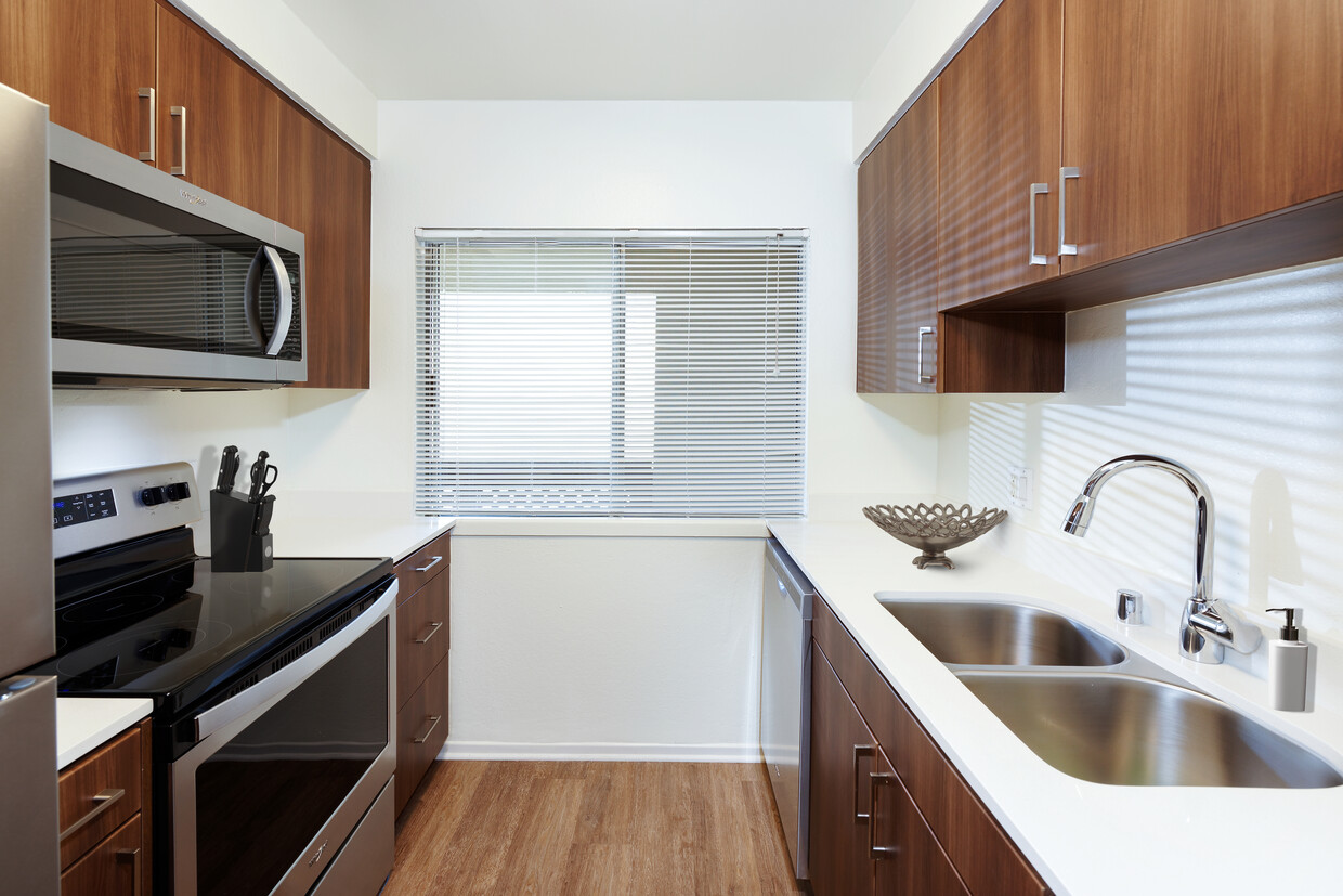 Renovated I kitchen with new cabinetry, quartz countertops, stainless steel appliances, and hard surface flooring - eaves Huntington Beach