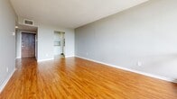 Located at 110 Boteler Street in Ottawa's vibrant Lowertown neighbourhood, this one-bedroom, one-bathroom unit offers a well-organized and efficient layout across a single floor. Warm-toned hardwood flooring flows consistently throughout the living areas and bedroom, creating a cohesive and inviting atmosphere.

The spacious living room is bright and open, featuring neutral grey walls and direct access to a private balcony through large floor-to-ceiling sliding glass windows that frame expansive outdoor views and allow abundant natural light to fill the space. A baseboard heating system runs along the exterior wall, ensuring year-round comfort.

The bedroom is a well-proportioned private retreat, also benefiting from large windows with balcony access and the same warm hardwood flooring. It offers ample space for furnishings and features clean, simple finishes throughout.

The kitchen is equipped with white cabinetry — both upper and lower units — paired with a warm stone-toned countertop. Wood-look flooring and built-in ventilation contribute to a clean, practical workspace.

The bathroom is finished with a vanity featuring under-sink storage, a mirrored medicine cabinet, and classic tiled flooring accents in soft green tones, providing a tidy and functional space.

Overall, the unit presents a clean, understated aesthetic with consistent finishes, ample natural light, and a practical flow suited for comfortable everyday living.