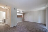 Located at 4000 Forest Creek Lane in West Deptford, NJ, this single-floor unit offers a well-organized and efficient layout across its four distinct areas. The combined kitchen and living room serves as the heart of the space, where soft neutral-toned walls and wall-to-wall carpeting create a warm, inviting atmosphere. Large vertical blinds adorn a sliding glass door and an additional window, allowing ample natural light to fill the room and offering views of the surrounding greenery.

The galley-style kitchen is a standout feature, designed for practical use with rich dark-wood cabinetry lining both sides of the corridor. Light-toned countertops provide generous prep space, while stainless steel appliances — including an electric range, a refrigerator, and a dishwasher — deliver essential functionality. Light hardwood-style flooring in the kitchen contrasts neatly with the carpeted living area.

The bathroom is clean and straightforward, featuring a combined tub and shower with a curtain rod, a toilet, and a vanity sink. A six-panel door and a louvered closet door frame the entrance, adding classic detail. A dedicated closet provides additional storage, completing this compact yet thoughtfully arranged space.