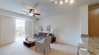 This single-floor residential unit offers a thoughtfully designed layout that balances comfort and functionality. The open-concept kitchen is a standout feature, equipped with stainless steel appliances including a refrigerator, gas range, and built-in microwave. Warm-toned wooden cabinetry pairs elegantly with granite countertops, which extend to a breakfast bar with seating — ideal for casual dining. Light tile flooring runs throughout the kitchen, adding a clean, polished look.

The living area is bright and welcoming, featuring soft carpeting, a ceiling fan, and a large sliding glass door that opens to a private balcony with outdoor views. Natural light fills the room, creating an airy and open atmosphere well-suited for relaxing or entertaining.

The bedroom is generously sized with plush carpeting, large windows with slatted blinds that allow abundant natural light, and convenient access to a walk-in closet. The room offers a calm, restful ambiance.

The bathroom maintains a crisp, clean aesthetic with light tile flooring, a white vanity with an integrated sink, a large mirror, and bright overhead lighting — delivering a practical yet tidy space. Overall, this unit presents a cohesive and comfortable living environment with modern finishes throughout.