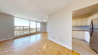 Located at 273 Pharmacy Ave in Toronto's Clairlea neighbourhood, this well-appointed one-bedroom, one-bathroom unit offers a thoughtfully designed layout across a single floor. The combined living and dining area is a standout feature, bathed in abundant natural light through expansive floor-to-ceiling windows that frame sweeping views of the surrounding greenspace and city skyline. Classic parquet wood flooring runs throughout the main living areas and bedroom, adding warmth and character to the space. A private balcony, accessible from the living area, extends the living space outdoors and showcases the elevated views. The kitchen is efficiently laid out with white cabinetry, subway tile backsplash, stainless steel appliances including a refrigerator and electric range, and light tile flooring — seamlessly connected to the main living area via an open passthrough. The bedroom is a comfortable size, featuring the same parquet flooring and a window that continues the unit's access to natural light and city views. The bathroom is clean and modern, appointed with a vanity featuring a stone-look countertop, an undermount sink, and a mirrored medicine cabinet. Overall, the unit presents a bright, functional, and inviting living environment.