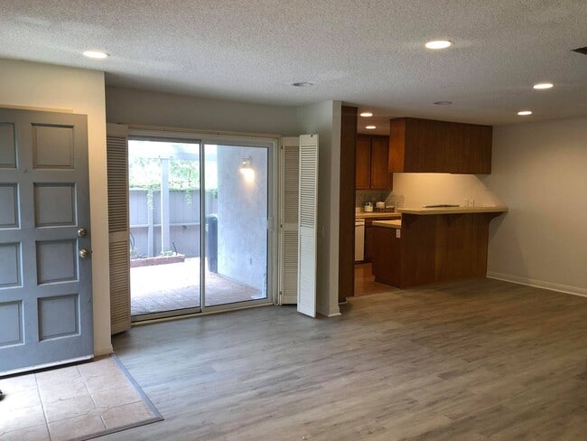 Living room; entrance to the far left, door to patio on the left, kitchen on the right - 9594 Easter Way