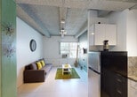 Located at 953 Collins Ave in the heart of Miami Beach, FL, this single-floor unit offers a practical and comfortable layout ideal for city living. The space features light-toned tile flooring throughout, creating a clean and cohesive aesthetic. Exposed concrete beams span the textured ceiling, adding an industrial character that contrasts with the bright white walls.

The living area provides a cozy yet functional setting, anchored by a cushioned sofa accented with yellow pillows, a coffee table atop a green area rug, and a wall-mounted television. A window unit provides climate control, and natural light filters in through the front window.

The kitchen is efficiently designed with dark granite countertops, glossy white cabinetry, and an L-shaped layout that maximizes the available space. It is equipped with a gas range, refrigerator, microwave, and coffee maker, making it fully functional for everyday use.

The bedroom is a serene, minimalist retreat with white walls, tile flooring, and a window with an air conditioning unit. Colorful wall art adds a vibrant touch to the otherwise calm aesthetic.

The bathroom is clean and straightforward, featuring a shower-tub combination with white tile surround, a vanity with sink, and a toilet — all finished in crisp white tones. This unit's location on Collins Ave places residents within easy reach of Miami Beach's renowned dining, nightlife, and shoreline.