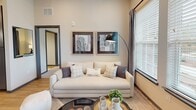 Located at 8108 Grace Farms Dr. in Charlotte, NC, this single-floor residence offers a thoughtfully designed layout with modern finishes and a warm, neutral color palette throughout. The open-concept kitchen serves as a central hub, showcasing a large granite-topped island with pendant lighting, two-tone cabinetry in white and slate gray, stainless steel appliances, a tile backsplash, and light hardwood-style flooring. An in-unit washer and dryer are conveniently accessible just off the kitchen. The living area is bright and welcoming, featuring large windows and a glass door that invite abundant natural light and provide outdoor views. High ceilings enhance the sense of openness, and the space is finished with tasteful, contemporary décor. The bedrooms are carpeted and well-proportioned, each offering generous closet space, including a walk-in closet with wire shelving systems. The primary bedroom features elevated ceilings and a transom-style window, while a secondary bedroom benefits from a large window framing outdoor greenery. The bathroom is finished with granite vanity counters, dark cabinetry, hardwood-style flooring, and a full tub-and-shower combination. Overall, the residence combines functional design with modern aesthetics to create a comfortable and stylish living environment.