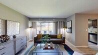 Located at 8501 Walther Blvd in Nottingham, Maryland, this single-floor residence offers a thoughtfully designed layout with a cohesive, contemporary aesthetic throughout. The living room serves as the heart of the home, anchored by large sliding glass doors that flood the space with natural light and provide views of the surrounding greenery. Light wood-style flooring, neutral gray walls, and a glass-top coffee table contribute to an open, modern feel. A dedicated dining area flows naturally from the living space, featuring light hardwood-style flooring, a round glass dining table, and a stylish flush-mount ceiling fixture that adds an elegant touch. The kitchen is well-equipped, showcasing rich dark cabinetry, granite countertops, a tile backsplash, stainless steel appliances, and in-unit laundry — all finished with light flooring that brightens the room. The bedroom offers plush carpeting, a large window with outdoor views, and ample space for restful living. A second bedroom provides additional comfortable accommodation, also with soft carpeting and generous natural light. The bathroom is clean and functional, featuring a tiled tub-shower combination, a dark wood vanity with a white countertop, and light flooring. Throughout, the residence maintains a consistent, modern design sensibility with warm accents and practical finishes.
