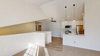 Located at 3686 Matador W in Traverse City, Michigan, this single-floor, 3-bedroom, 1-bathroom home offers a thoughtfully designed layout with clean, contemporary finishes throughout. The open-concept kitchen is a standout feature, showcasing vaulted ceilings that lend an airy sense of height, crisp white shaker cabinetry, light quartz countertops, and a peninsula with a built-in sink. Stainless steel appliances—including a range, microwave, and refrigerator—complement the space, while stylish pendant lights with glass shades and recessed lighting add a modern touch. Light wood-look vinyl flooring runs through the kitchen and main areas, transitioning to soft, neutral carpet in the living and bedroom spaces. The spacious primary bedroom benefits from abundant natural light and a ceiling fan, while the two additional bedrooms each feature windows with outdoor views, ceiling fans, and comfortable carpeting. The full bathroom is finished with a white tub-shower combination, wood-look flooring, a vanity with marble-style countertop, and matte black fixtures for a cohesive, modern aesthetic. A dedicated laundry room houses a full-size front-loading washer and dryer. Hallways connect the spaces efficiently, completing this well-appointed home.