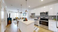 Located at 400 North Rome Avenue in Tampa's vibrant Hyde Park neighborhood, this modern one-bedroom, two-bathroom residence offers a thoughtfully designed open-concept layout. Light wood-tone flooring flows throughout, creating a warm and cohesive aesthetic.

The kitchen is a standout feature, showcasing sleek white cabinetry extending to the ceiling, a grey subway tile backsplash, quartz countertops, and a full suite of stainless steel appliances including a range, microwave, dishwasher, and refrigerator. A central island with pendant lighting provides additional prep space and casual seating, opening seamlessly into the living room.

The living room is bright and inviting, filled with natural light through large windows with plantation shutters and a ceiling fan overhead. Sliding doors lead to a private balcony, extending the living space outdoors.

The bedroom is a comfortable retreat, featuring windows that invite natural light, a ceiling fan, and direct access to a dedicated closet and en-suite bathroom. The two bathrooms are clean and modern, each offering a full tub-shower combination with white tile surround and a wide vanity with contemporary cabinetry. This well-appointed residence combines efficient use of space with modern finishes in a prime Tampa location.