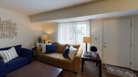 This two-story residence at Trader Court East in South Bend, Indiana offers a well-organized and comfortable layout across two floors, connected by a carpeted staircase visible from the entry area. The living room is bright and inviting, featuring a large window with vertical blinds that allows generous natural light to fill the space. The dining area is a defined room with carpet flooring and a ceiling fan with integrated lighting, providing a practical and pleasant setting for meals. The kitchen is equipped with warm wood-tone cabinetry, a gas range, dishwasher, and a classic tile backsplash, offering ample storage and counter space for everyday cooking. The primary bedroom is generously sized with carpet flooring, a closet, and a window overlooking the surrounding neighborhood. A second bedroom mirrors a similar layout, also featuring carpet flooring, a closet, and a window that brings in natural light. The full bathroom includes wood-style flooring, a vanity with cabinetry, and a tub-shower combination. Throughout the residence, the neutral color palette and consistent carpeting create a cohesive and comfortable atmosphere, making this a practical multi-bedroom home suitable for families or those seeking multi-level living in the South Bend area.