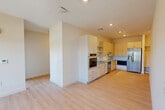 This well-appointed three-bedroom, two-bathroom unit in Waltham, MA offers a clean, modern design throughout its single-level layout. Light-toned hardwood flooring flows seamlessly across all living areas, complementing the bright, neutral color palette and recessed lighting that give the space an open, airy feel.

The kitchen is a standout feature, outfitted with light wood cabinetry, granite countertops, a subway tile backsplash, and a full suite of stainless steel appliances including a side-by-side refrigerator with ice dispenser, wall oven, dishwasher, and built-in microwave. A built-in mudroom nook adjacent to the kitchen adds convenient everyday storage. The kitchen opens directly into the combined dining and living area, creating an inclusive, functional layout ideal for daily living and entertaining.

The three bedrooms are well-sized and filled with natural light from large windows that offer views of the surrounding landscape and neighborhood. Closet space is generously provided, with multiple closets distributed throughout the unit. The primary bedroom includes a double-door closet.

Both bathrooms are finished with tile flooring and granite-topped vanities. One bathroom features an accessible roll-in shower with grab bars and a handheld showerhead. The unit also includes a dedicated laundry area, adding to its practical appeal.