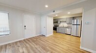 Located at 10710 Beaver Dam Rd in Cockeysville, MD, this thoughtfully designed one-bedroom, two-bathroom unit makes excellent use of its compact footprint. Light-toned luxury vinyl plank flooring runs throughout, complementing neutral wall colors and clean white trim to create a bright, cohesive aesthetic.

The open-concept layout seamlessly combines the living room, dining area, and kitchen into one functional space. The kitchen is outfitted with gray shaker-style cabinetry, granite countertops, a stainless steel sink, and a full suite of stainless steel appliances including a refrigerator, range, microwave, and dishwasher. Recessed lighting illuminates the kitchen and living areas effectively.

The living room benefits from multiple windows fitted with white blinds, allowing natural light to fill the space. The bedroom features crown molding, a window overlooking greenery, and access to closet storage. Two closets are included throughout the unit, providing practical storage solutions.

The bathrooms are finished with matching gray cabinetry and granite countertops, consistent with the kitchen's design language. One bathroom conveniently houses an in-unit washer, adding everyday practicality. A utility room and a smart lock entry door round out the well-appointed features of this efficiently designed Cockeysville residence.