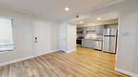 Located at 10710 Beaver Dam Rd in Cockeysville, MD, this thoughtfully designed one-bedroom, two-bathroom unit makes excellent use of its compact footprint. Light-toned luxury vinyl plank flooring runs throughout, complementing neutral wall colors and clean white trim to create a bright, cohesive aesthetic.

The open-concept layout seamlessly combines the living room, dining area, and kitchen into one functional space. The kitchen is outfitted with gray shaker-style cabinetry, granite countertops, a stainless steel sink, and a full suite of stainless steel appliances including a refrigerator, range, microwave, and dishwasher. Recessed lighting illuminates the kitchen and living areas effectively.

The living room benefits from multiple windows fitted with white blinds, allowing natural light to fill the space. The bedroom features crown molding, a window overlooking greenery, and access to closet storage. Two closets are included throughout the unit, providing practical storage solutions.

The bathrooms are finished with matching gray cabinetry and granite countertops, consistent with the kitchen's design language. One bathroom conveniently houses an in-unit washer, adding everyday practicality. A utility room and a smart lock entry door round out the well-appointed features of this efficiently designed Cockeysville residence.
