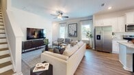This contemporary 1350 square foot residence offers a harmonious blend of style and functionality across two well-designed floors. The home boasts three bedrooms, including a spacious 190 square foot primary suite, and two full bathrooms. The open-concept layout seamlessly integrates the kitchen and living areas, creating an inviting space for both relaxation and entertainment.

The interior is characterized by a neutral color palette, emphasizing clean lines and natural light. Wood-look flooring extends throughout, adding warmth and continuity. The kitchen showcases white cabinetry, stainless steel appliances, and a generous island with granite countertops, perfect for casual dining or food preparation.

Bedrooms are thoughtfully appointed with ample closet space and large windows. Bathrooms feature modern fixtures, including sleek vanities and combination tub-shower units. The living area is adorned with a ceiling fan and offers direct access to outdoor views.

Attention to detail is evident in the home's design, with tray ceilings, contemporary light fixtures, and strategically placed artwork enhancing the overall aesthetic. The property's layout, with 590 square feet on the ground floor and 760 square feet upstairs, ensures a comfortable and efficient use of space for modern living.