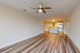 Located in Melbourne, FL, this single-story, 3-bedroom, 2-bathroom home offers a thoughtfully designed open-concept layout with modern finishes throughout. The expansive living area features warm wood-look plank flooring, a ceiling fan with light fixture, and a seamless flow into the kitchen — ideal for everyday living and entertaining. The kitchen is a standout, boasting two-tone cabinetry with white uppers and gray lowers, a striking decorative tile backsplash, stainless steel appliances including a refrigerator and wall oven, a sleek range hood, white quartz countertops, a center island with pendant lighting, and a barn door accent. A mudroom-style hallway entry with built-in hooks and a bench adds practical charm. The bedrooms are carpeted for comfort, each equipped with ceiling fans. The generously sized primary bedroom includes a walk-in closet with built-in shelving and hanging rods. The bathroom impresses with navy cabinetry, dual sinks, gold hardware accents, and wood-look tile flooring. Additional highlights include a dedicated laundry room with washer and dryer, a closet with ample storage, and a rear door offering natural light to the living area.