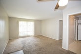 This single-floor unit offers a practical and comfortable layout designed for everyday living. The spacious living area greets you upon entry, featuring neutral-toned carpet, a textured ceiling, and a ceiling fan overhead. A tiled entryway transitions seamlessly into the carpeted main space, which flows openly toward the kitchen and bedroom areas.

The kitchen is efficiently designed with white cabinetry, dark countertops, a double-basin sink, and white appliances including a refrigerator, electric range, and dishwasher. Light tile flooring and under-cabinet ventilation complete the functional workspace.

The bedrooms are generously sized, each featuring wall-to-wall carpet, neutral wall tones, textured ceilings, and vertical blinds that allow natural light to filter in. One bedroom offers a single reach-in closet, while the other is notably well-appointed with dual reach-in closets, providing ample storage. Both rooms maintain a calm, understated ambiance ideal for rest and relaxation.

The bathroom includes tile flooring, a tub and shower combination with tiled surround, a toilet, and a vanity topped with dark countertops and white cabinetry below. A towel bar and clean, simple finishes round out this functional space. Overall, the unit presents a clean, move-in-ready environment with consistent neutral tones throughout.