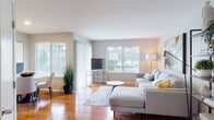 Located at 1416 Carolina Ct in Schaumburg, Illinois, this single-floor home offers a thoughtfully designed layout with consistent warm-toned hardwood flooring throughout. The living room serves as the heart of the space, featuring multiple large windows with vertical and horizontal blinds that allow generous natural light to fill the room, offering views of the surrounding greenery. The open layout connects seamlessly to a cozy dining nook, which benefits from its own window and a sliding glass door draped in sheer vertical blinds.

The kitchen is well-appointed with crisp white shaker-style cabinetry, granite countertops, and a full suite of stainless steel appliances, including a range, over-the-range microwave, and refrigerator. The hardwood flooring continues here, maintaining a cohesive feel throughout.

The bedroom is a tranquil retreat, featuring multiple windows on adjacent walls that invite natural light from multiple directions, and is finished with the same warm hardwood floors. The bathroom is clean and functional, featuring a white vanity with granite countertops, a tub-shower combination, and hardwood flooring. The overall ambiance of the home is light, modern, and welcoming.