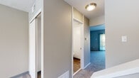 This well-designed three-bedroom, two-bathroom home spans three floors, offering a thoughtful layout that balances comfort and functionality. The entry level provides a compact and efficient footprint, leading upward to the main living floor, which serves as the heart of the home. This level features a generous living area with plush carpeting, neutral tones, and built-in shelving — ideal for both relaxation and organization. A standout feature of this floor is access to a spacious outdoor deck, enclosed by a black metal railing and offering sweeping views of surrounding treetops and greenery under open skies.

The upper floor houses all three bedrooms, including a notably large primary bedroom with dual windows that invite ample natural light. Each bedroom is carpeted and equipped with sliding-door closets providing practical storage. The two bathrooms are cleanly finished with wood-look plank flooring, granite-style countertops, undermount sinks, and efficient layouts. Hallways connect the spaces with ease, and a utility room adds further practicality. Throughout the home, a consistent neutral palette, flush-mount ceiling lighting, and well-maintained finishes contribute to a clean, move-in-ready ambiance.