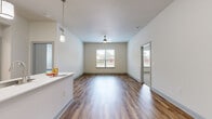 This single-story, 2-bedroom, 2-bathroom residence in Houston, TX offers a thoughtfully designed open-concept layout with modern finishes throughout. The spacious living room features rich wood-look flooring, a ceiling fan, and a large window that fills the space with natural light while offering outdoor views. It connects seamlessly to the dining area and a well-equipped kitchen, making the combined space ideal for everyday living and entertaining.

The kitchen is a standout feature, boasting a central island with a sink and light stone countertops, white upper cabinetry, gray lower cabinets, a tile backsplash, stainless steel appliances, and pendant lighting overhead. A pantry and in-unit laundry area add practical convenience.

The generously sized primary bedroom continues the wood-look flooring and includes a ceiling fan, a bright window, and a walk-in closet with built-in shelving and hanging rods. The secondary bedroom is finished with plush carpet and a panel door. Three closets in total provide ample storage throughout the home.

Both bathrooms are clean and modern, with one featuring a tiled soaking tub and shower combo, tile flooring, and contemporary vanity fixtures. The neutral color palette and consistent finishes give the entire residence a cohesive, move-in-ready feel.