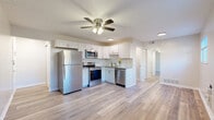 Located at 890 W Loveland Ave in Loveland, Ohio, this thoughtfully designed one-bedroom, two-bathroom residence makes excellent use of its single-floor layout. Light wood-style flooring flows seamlessly throughout, creating a cohesive and clean aesthetic across every room.

The kitchen is a standout feature, showcasing white shaker cabinetry, granite countertops, a classic subway tile backsplash, and a full suite of stainless steel appliances including a refrigerator, electric range, built-in microwave, and dishwasher. A ceiling fan with integrated lighting overhead enhances the open feel of the space where the kitchen connects to the living area.

The living room benefits from multiple windows that draw in natural light and offer outdoor views, further complemented by a ceiling fan. The bedroom, a comfortable and well-proportioned space, also features a ceiling fan and a window providing natural light and views to the exterior.

The bathrooms are finished with clean, modern detailing — one includes a full tub and shower combo with white subway tile surround and brushed gold hardware. Additional conveniences include three closets, a dedicated utility room, a hallway, and an entrance area, ensuring practical storage and functionality throughout. The neutral color palette and updated finishes give the entire space a fresh, move-in-ready appeal.