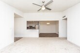 Located on Noble Creek Drive NW in Atlanta's 30318 zip code, this single-floor residence offers a thoughtfully updated interior with a mix of hard-surface and carpeted flooring throughout. The open living area is distinguished by vaulted ceilings and a ceiling fan, lending the space a generous, airy feel. Natural light filters in through multiple windows, offering views of surrounding greenery.

The kitchen is well-appointed with stainless steel appliances — including a gas range, microwave, dishwasher, and refrigerator — complemented by granite countertops, a tile backsplash, and ample cabinetry finished in a neutral tone. Wood-look flooring runs through the kitchen and adjoining areas, transitioning to plush carpet in the living and bedroom spaces.

The bathroom features a granite vanity countertop, a large mirror, wood-look tile flooring, and a tub-shower combination with decorative tile surround and glass enclosure. Bedrooms are carpeted and receive natural light through windows overlooking wooded surroundings. The entryway offers wood-look flooring and provides a clean transition into the main living areas, completing a cohesive and updated interior.